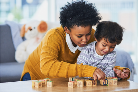 mother and child playing with learning blocks on table